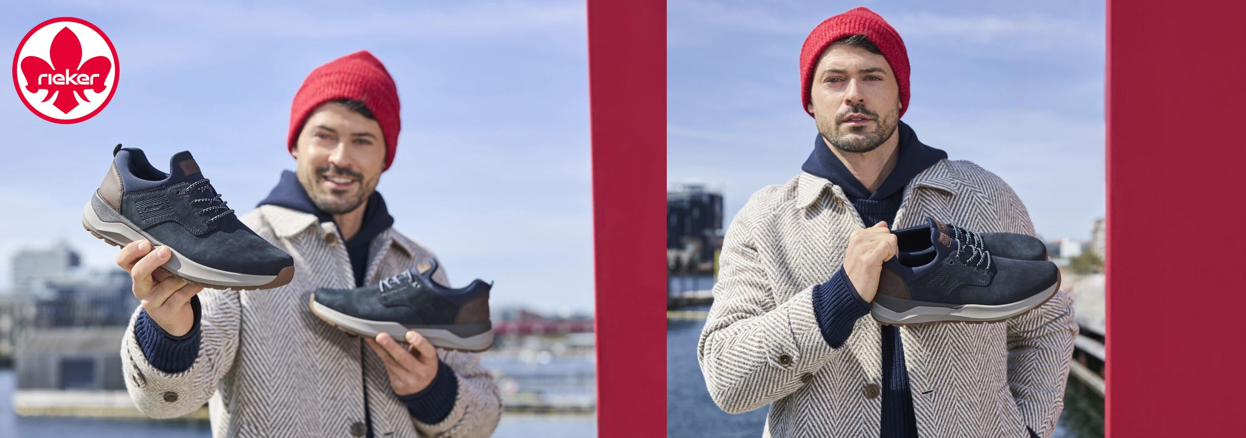 Man holding and showing off black sneakers with a red beanie and gray jacket against a cityscape background.