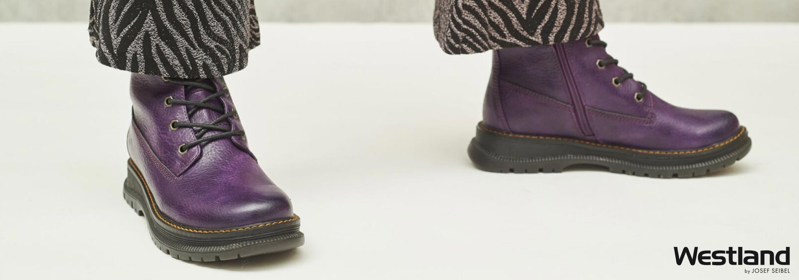Purple leather boots worn with patterned pants on a white background, featuring the Westland brand.
