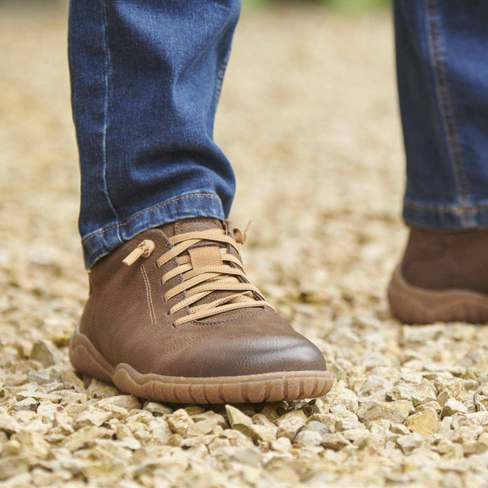 a pair of brown josef seibel shoes standing on gravel