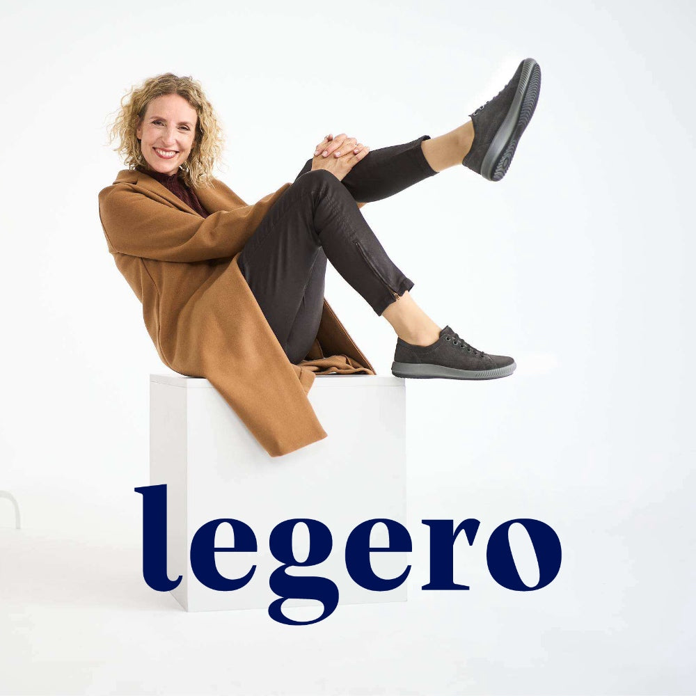 woman sitting on a white background wearing dark legero shoes