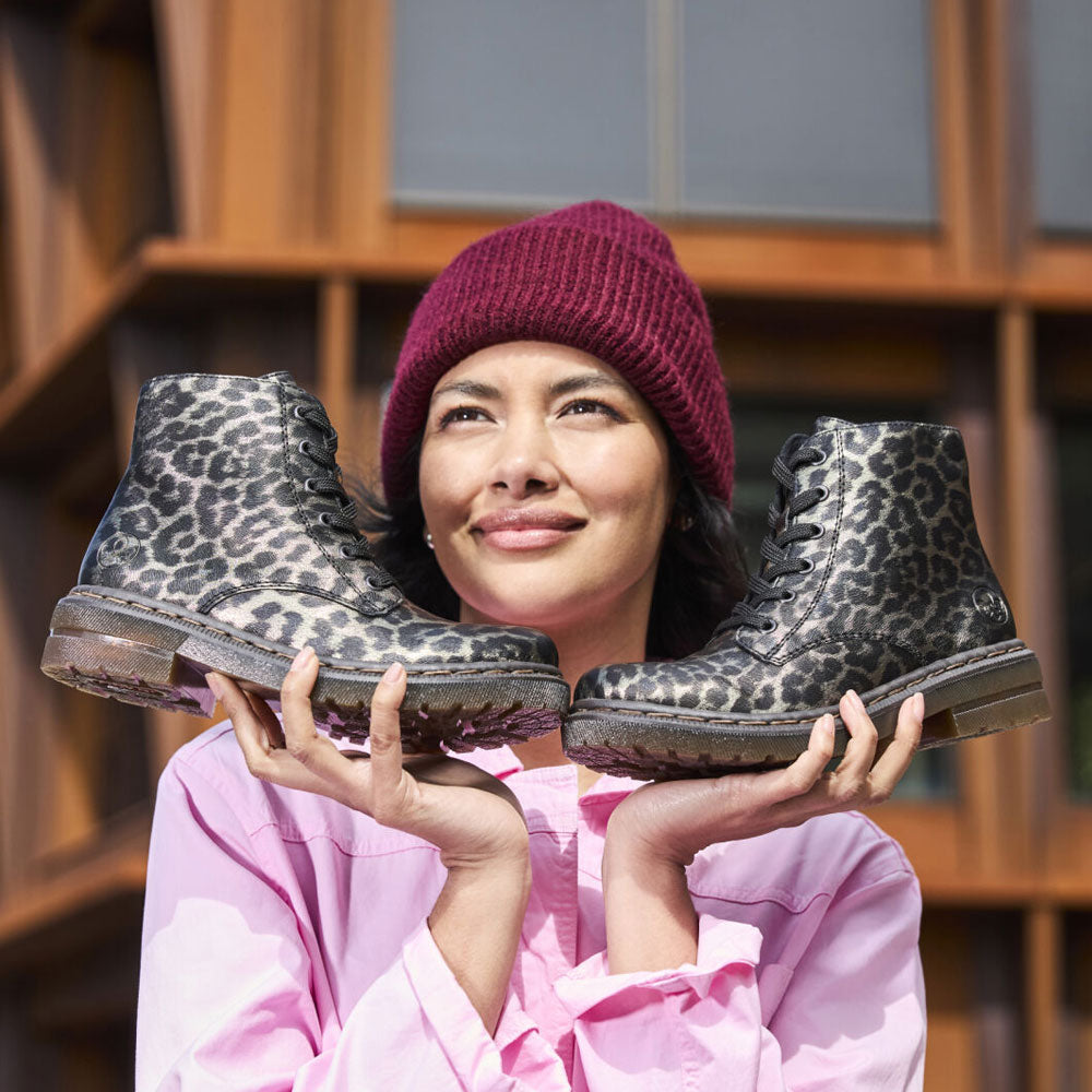 Person holding black patterned boots