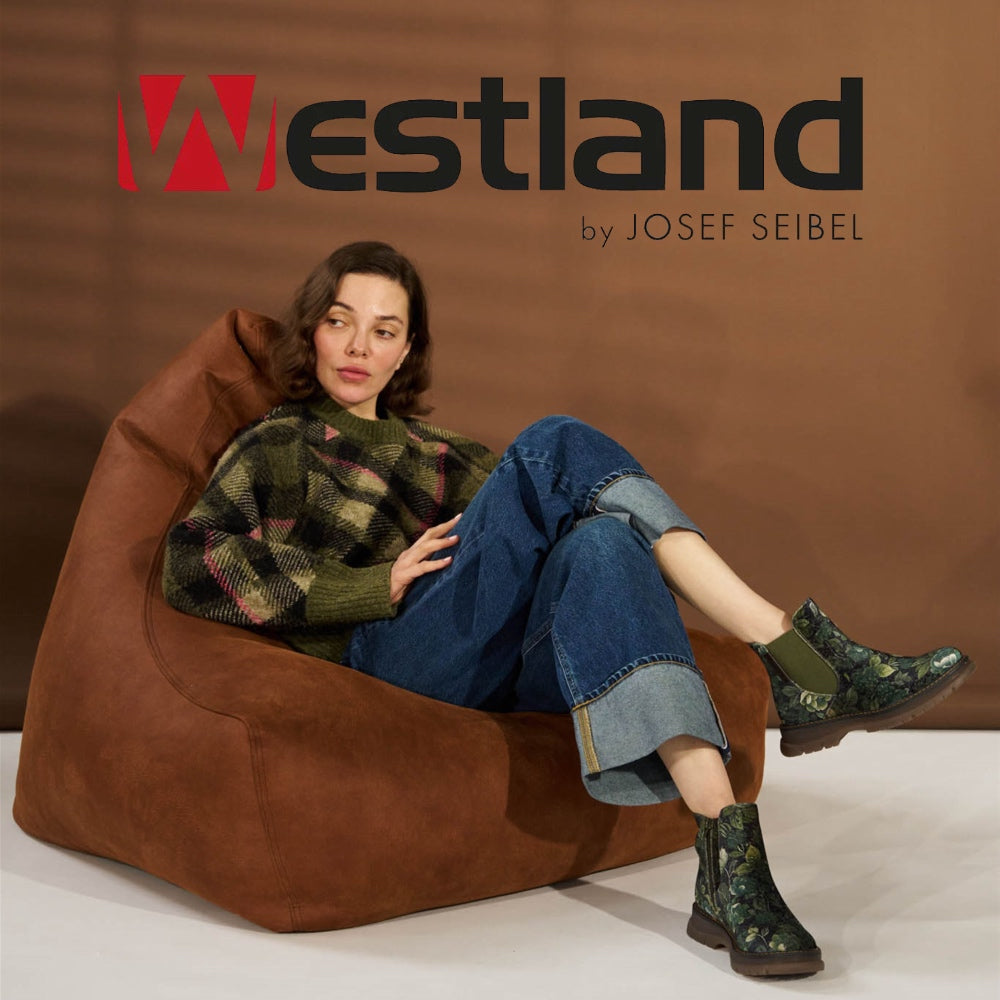 a woman sitting on a bean bag wearing green boots